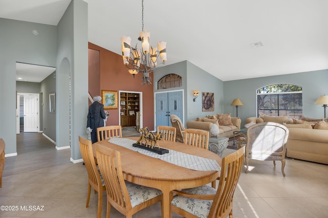 tiled dining room with lofted ceiling and a notable chandelier