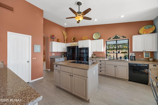 kitchen featuring white cabinets, sink, a kitchen island, and black appliances