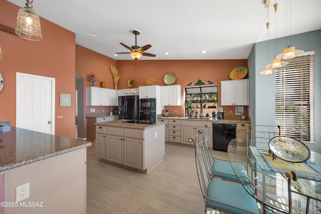 kitchen with hanging light fixtures, black appliances, white cabinets, and a kitchen island