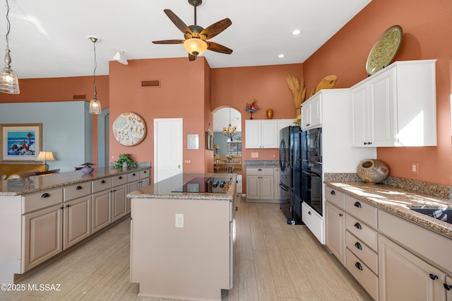 kitchen with black appliances, a center island, hanging light fixtures, light wood-type flooring, and white cabinets