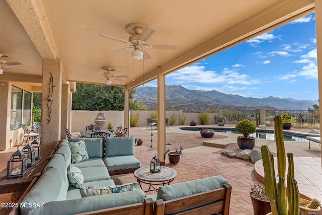 view of patio / terrace with a mountain view, an outdoor living space, a fenced in pool, and ceiling fan