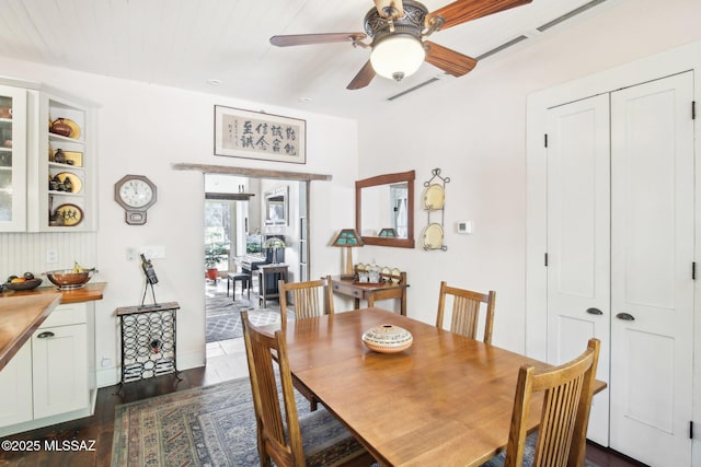 dining space featuring ceiling fan and dark wood-type flooring