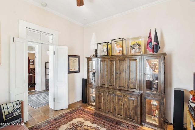 interior space featuring ceiling fan, crown molding, and tile patterned flooring