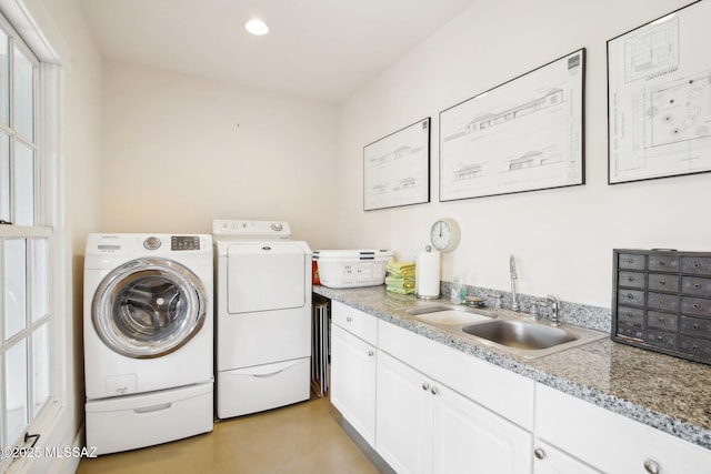 laundry room with sink, washing machine and clothes dryer, and cabinets