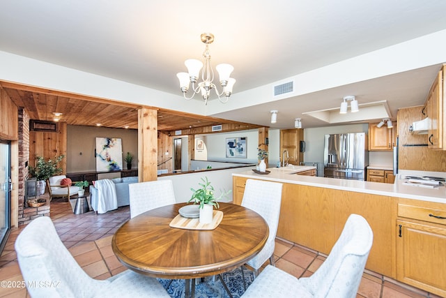 tiled dining area with sink and an inviting chandelier