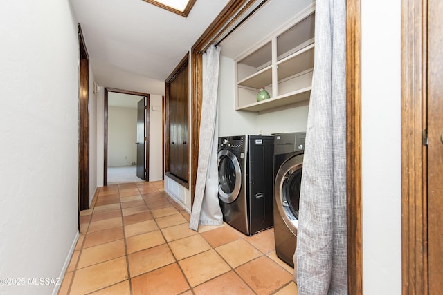 laundry room with washing machine and dryer and light tile patterned flooring