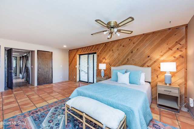 tiled bedroom featuring ceiling fan and wooden walls