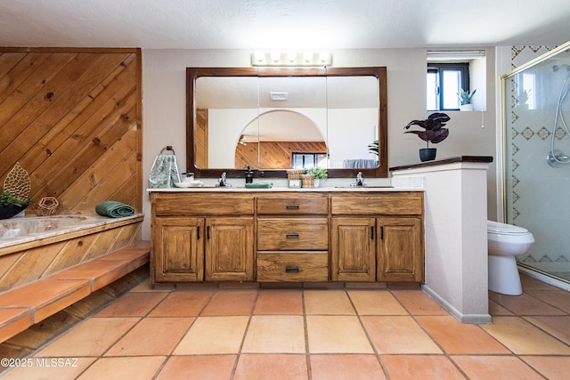 bathroom featuring an enclosed shower, vanity, tile patterned floors, and wooden walls