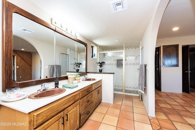 bathroom featuring a shower with door, vanity, and tile patterned flooring