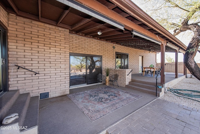 view of exterior entry with a patio