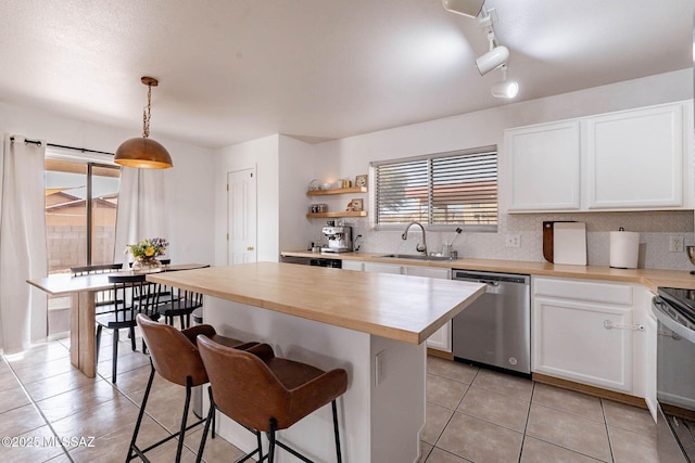 kitchen featuring sink, white cabinets, pendant lighting, and appliances with stainless steel finishes