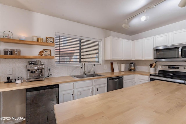 kitchen featuring white cabinets, stainless steel appliances, wooden counters, and sink