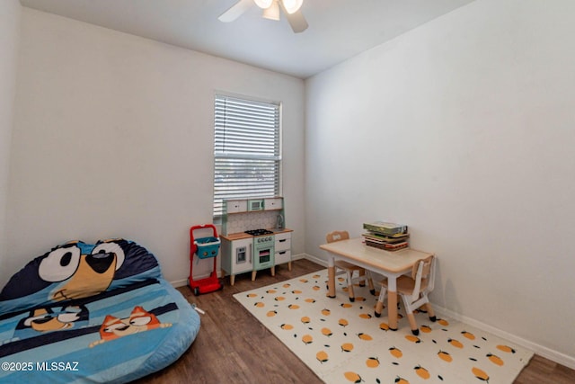 recreation room with ceiling fan and dark wood-type flooring