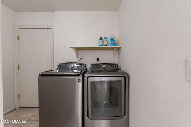 clothes washing area with separate washer and dryer and light tile patterned floors