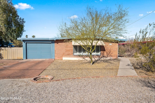 view of front of property featuring a garage, decorative driveway, and brick siding