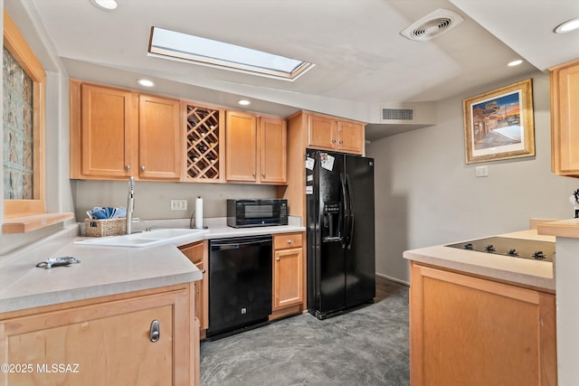 kitchen featuring black appliances, visible vents, light countertops, and a sink