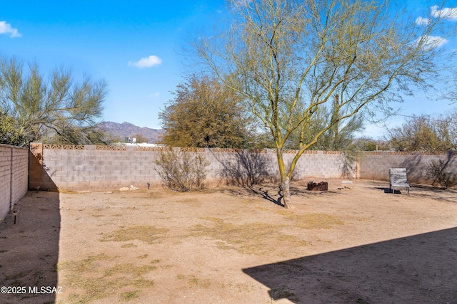 view of yard with a fenced backyard and a mountain view