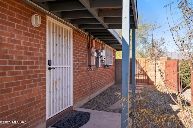 view of property exterior with brick siding and fence