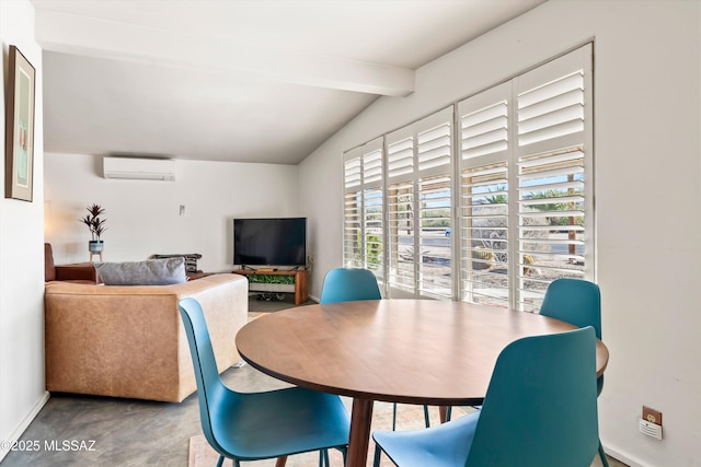 dining space featuring concrete floors, a wall unit AC, and vaulted ceiling with beams