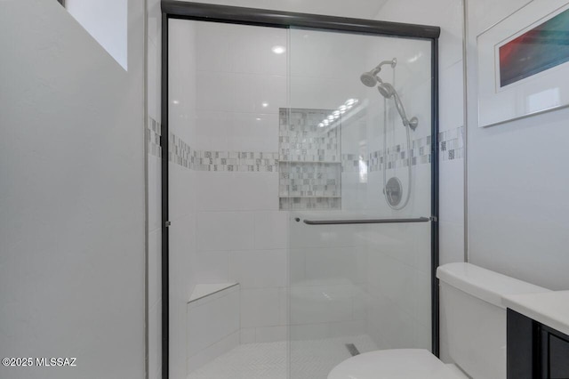 bathroom with a shower with shower door and toilet