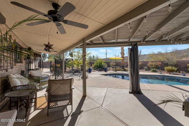 view of patio / terrace with a fenced in pool and ceiling fan