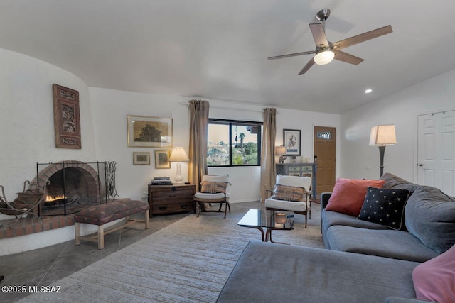 living room featuring a brick fireplace, lofted ceiling, and ceiling fan