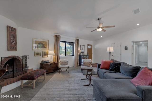 living room with ceiling fan, vaulted ceiling, and a brick fireplace