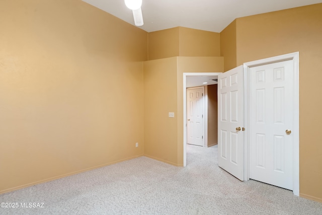 unfurnished bedroom with ceiling fan and light colored carpet