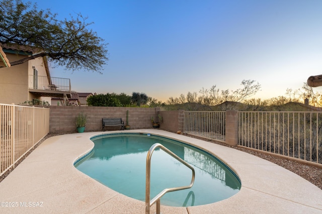 pool at dusk featuring a patio