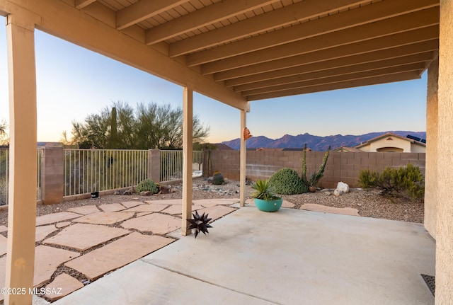 patio terrace at dusk featuring a mountain view