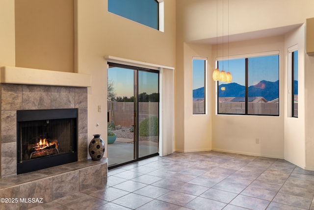 unfurnished living room with a tile fireplace and tile patterned floors