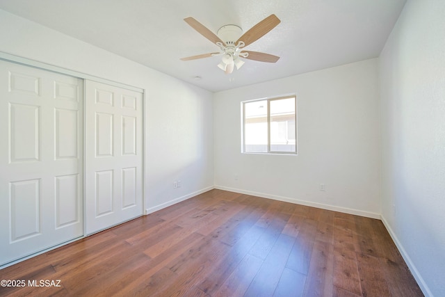 unfurnished bedroom featuring dark hardwood / wood-style floors, a closet, and ceiling fan