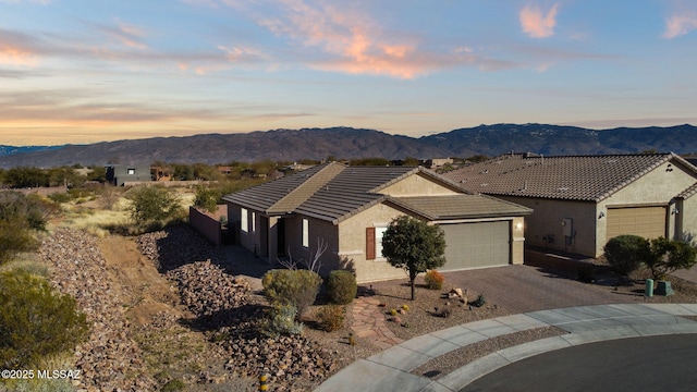 ranch-style home with a garage and a mountain view