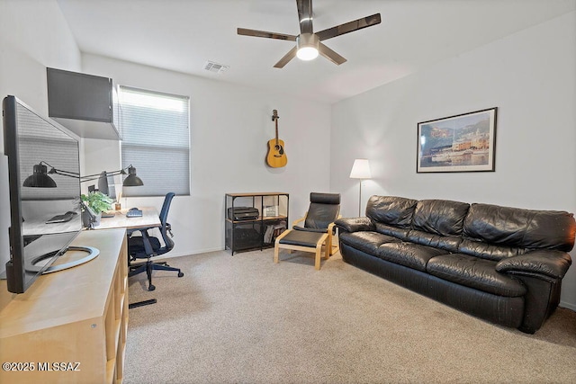 carpeted home office featuring ceiling fan