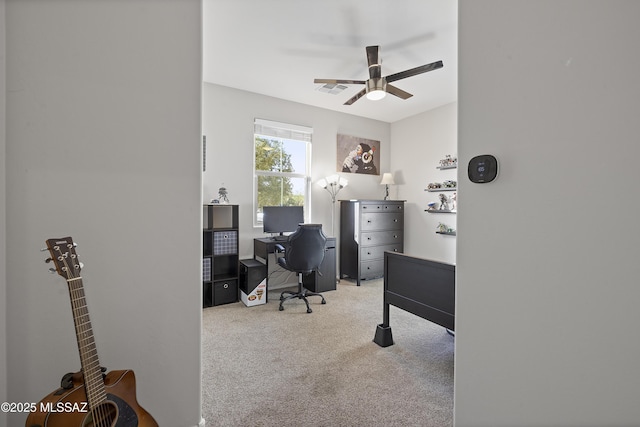 carpeted home office featuring ceiling fan