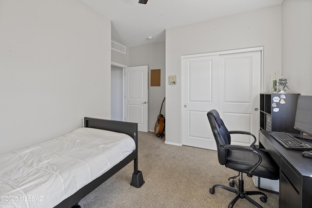 bedroom with ceiling fan, light colored carpet, and a closet