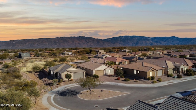 aerial view at dusk featuring a mountain view