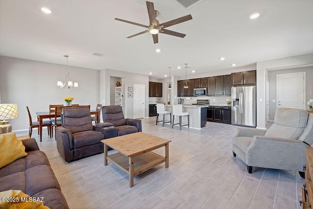 living room with ceiling fan with notable chandelier