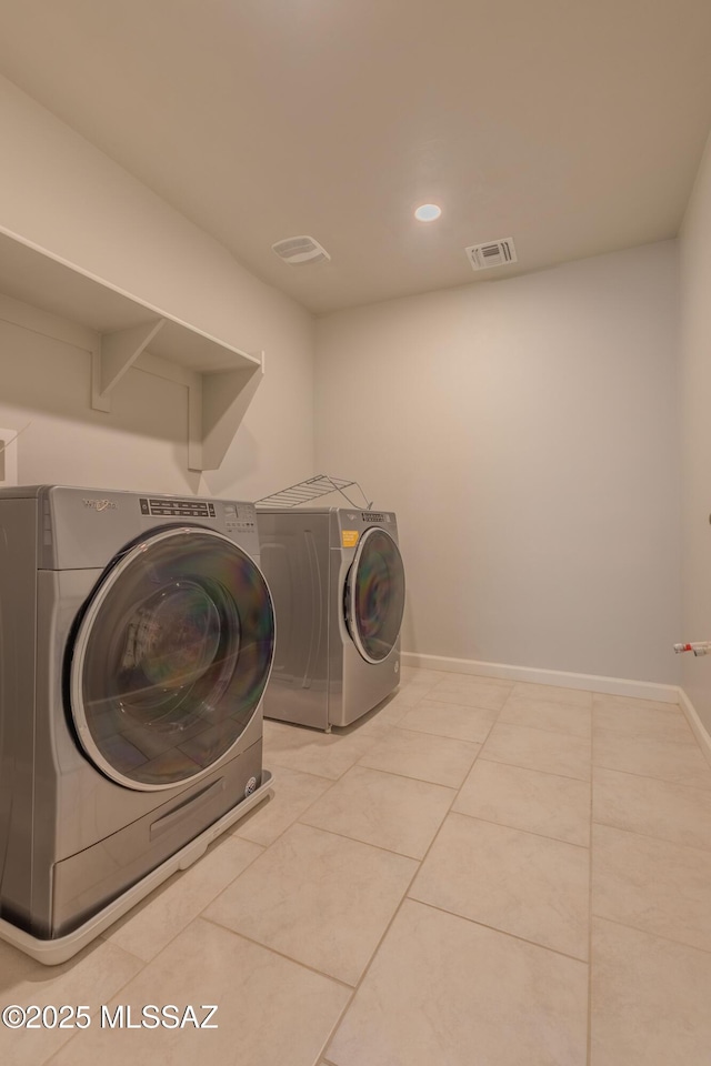 laundry area featuring light tile patterned flooring and washer and dryer