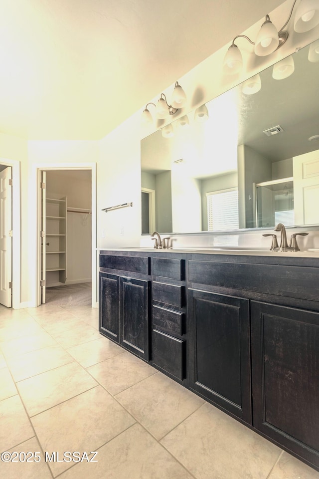 bathroom featuring a shower with door, vanity, and tile patterned floors