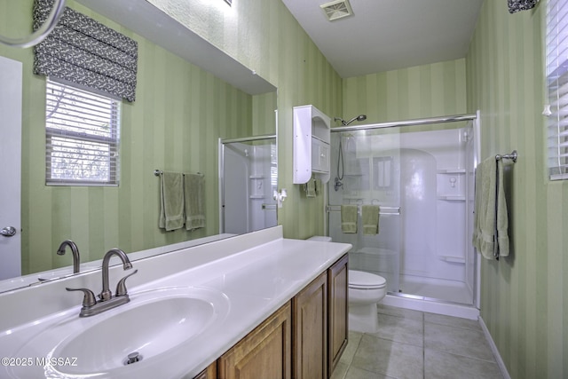 bathroom featuring tile patterned floors, toilet, an enclosed shower, and vanity