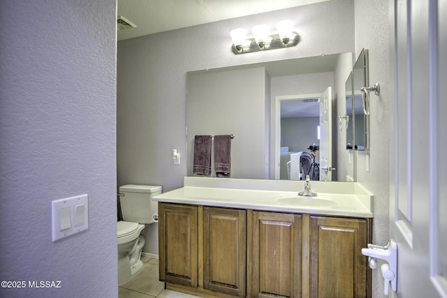 bathroom with tile patterned flooring, vanity, and toilet