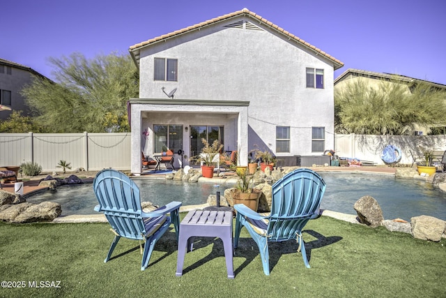 back of house featuring a fenced in pool, a yard, and a patio area