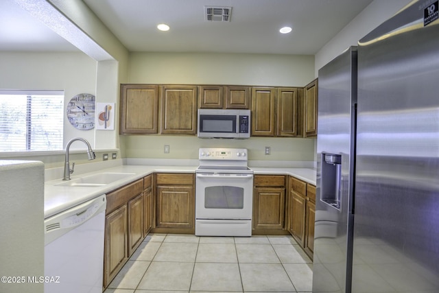 kitchen featuring stainless steel appliances, sink, and light tile patterned floors