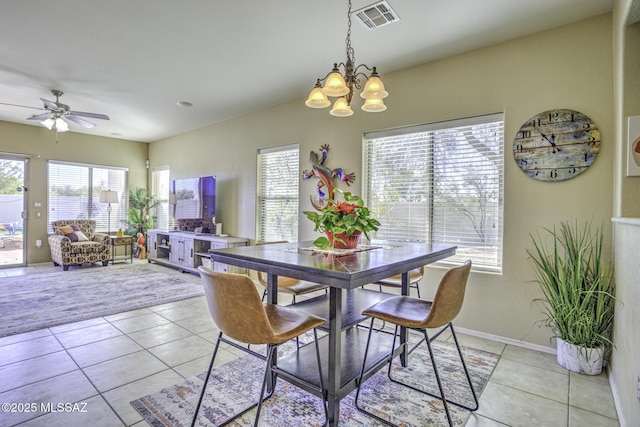 tiled dining space with ceiling fan with notable chandelier