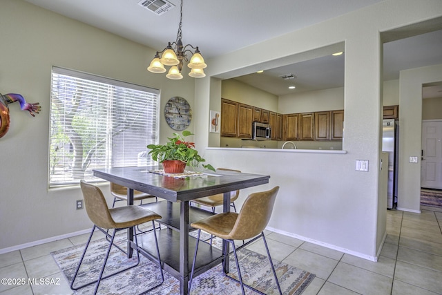 dining space with light tile patterned floors and a chandelier