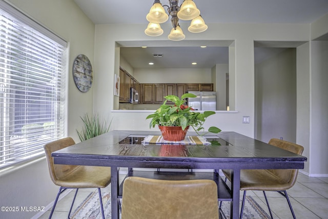 tiled dining room with a notable chandelier