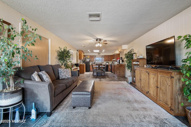 living room with a textured ceiling and ceiling fan