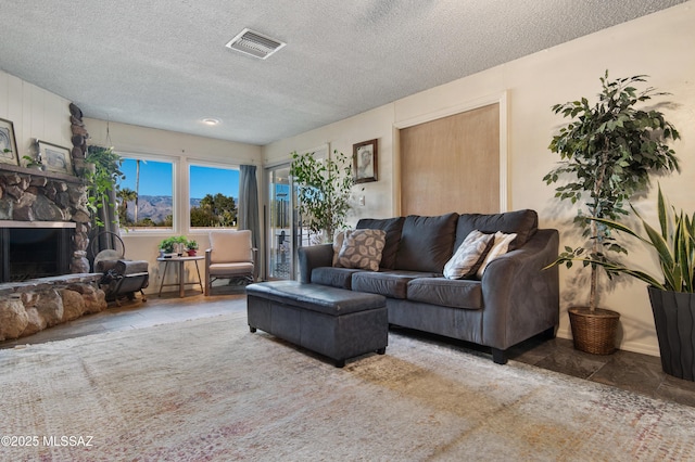 living room featuring a textured ceiling and a fireplace