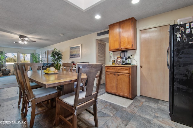 dining space featuring ceiling fan and a textured ceiling